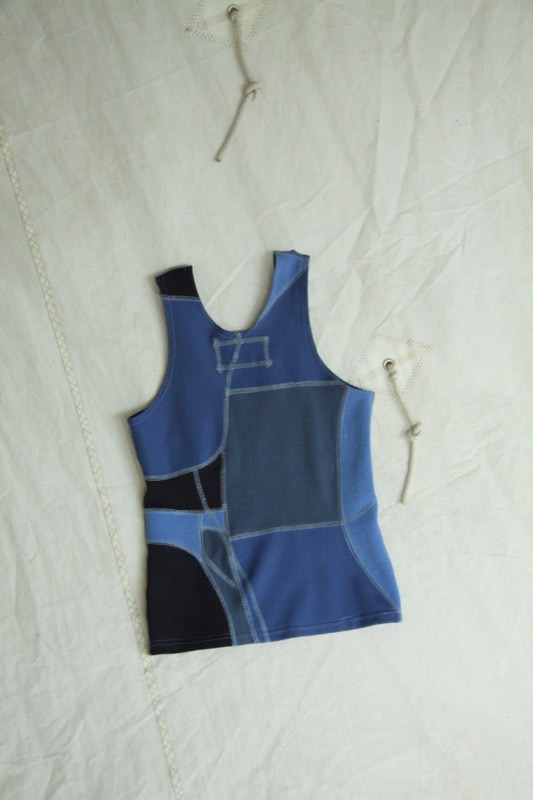 A patchwork tank pieced from navy, mid-blue and pale blue denim and jersey with curved panel seams and contrast topstitching.