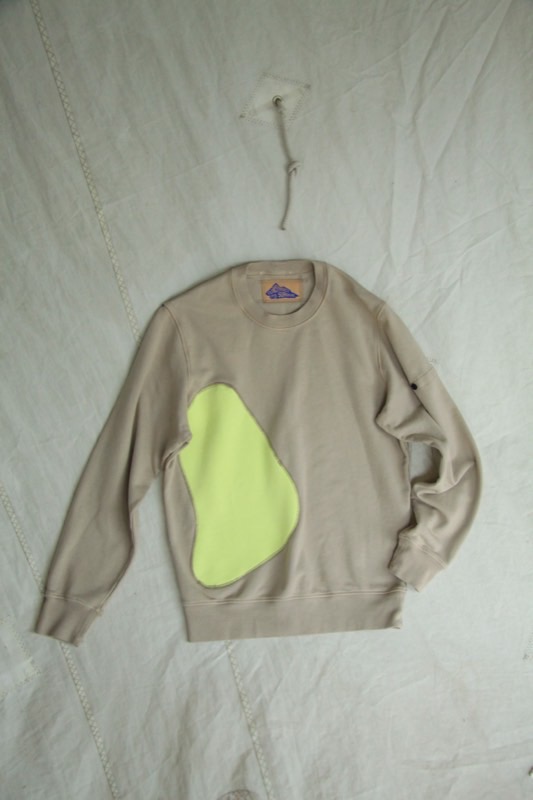 A sand crewneck sweatshirt with a large organic neon lime applique across the chest.