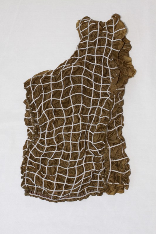 A one-shoulder bodice in olive bronze satin whose whole surface is held by a couched white cord lattice.